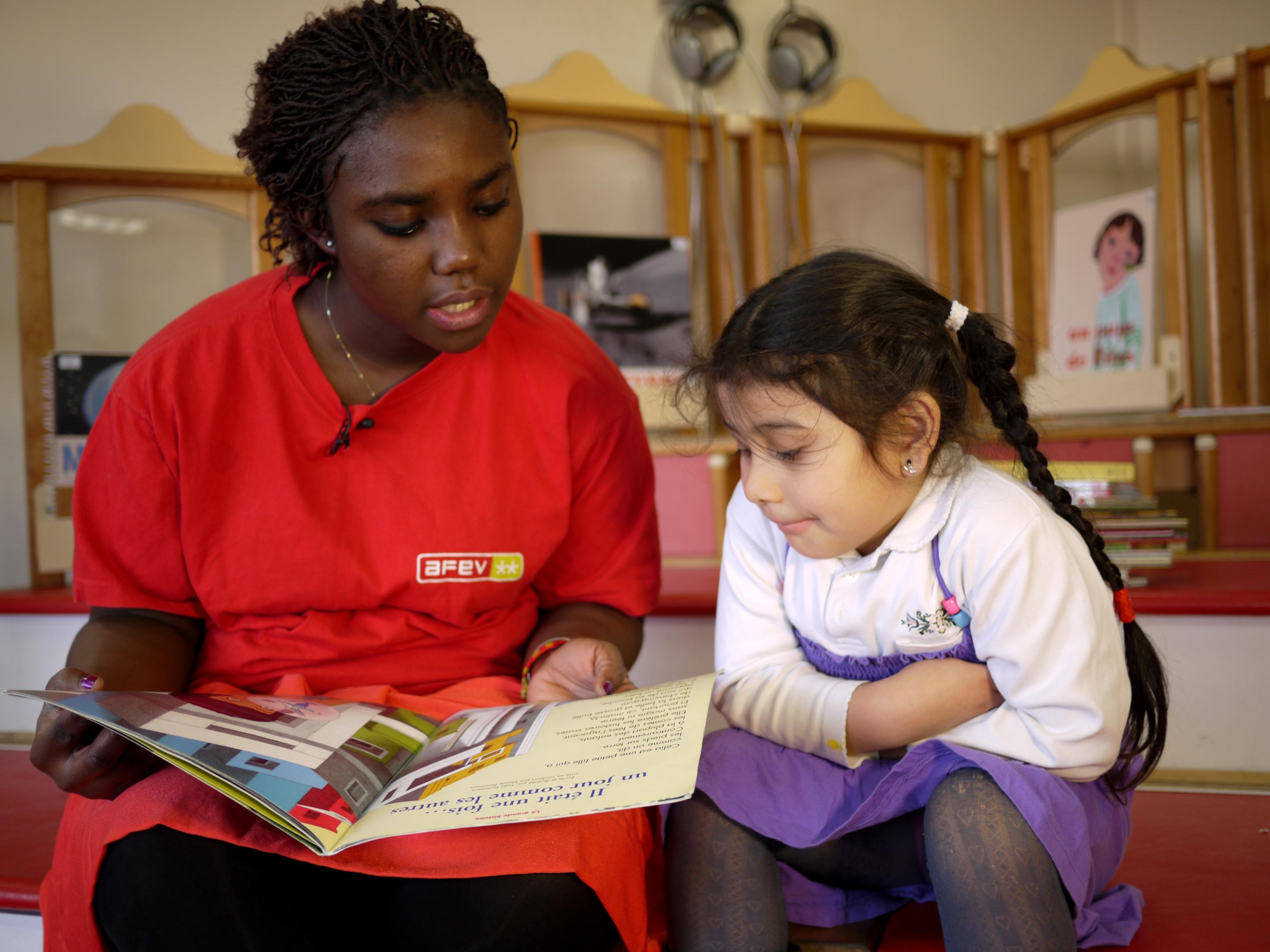 Etudiante faisant la lecture à une enfant