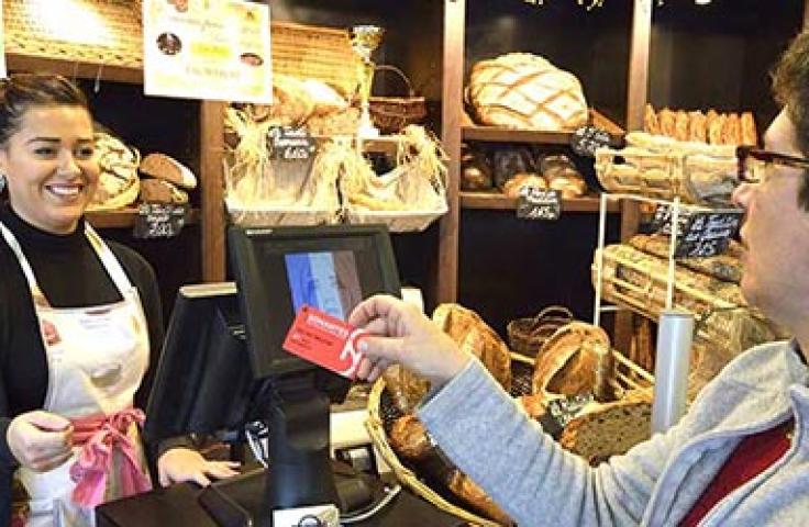 Femme payant avec sa carte SoNantes dans une boulangerie