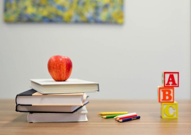 Livres d'écoles empilés avec une pomme au dessus