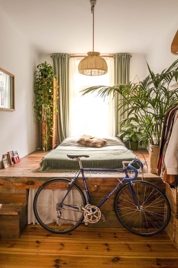 Chambre bohème avec lit, parquet, plantes et vélo