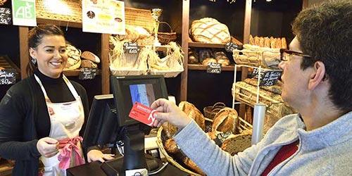 Femme payant avec sa carte SoNantes dans une boulangerie