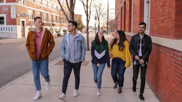 5 jeunes marchant sur un trottoir 